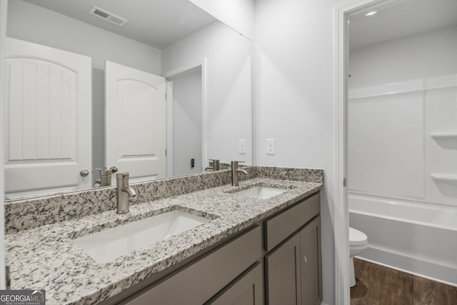 full bathroom with vanity, wood-type flooring, shower / bathtub combination, and toilet