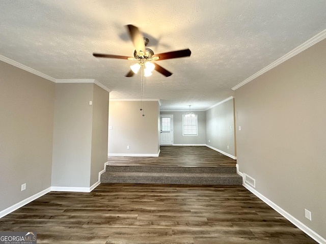 unfurnished room featuring ceiling fan with notable chandelier, dark hardwood / wood-style flooring, ornamental molding, and a textured ceiling