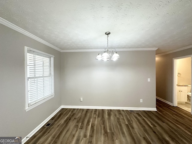 empty room with dark hardwood / wood-style flooring, ornamental molding, a textured ceiling, and an inviting chandelier