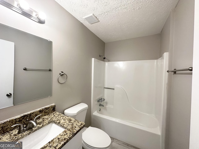 full bathroom with vanity, a textured ceiling, toilet, and shower / washtub combination