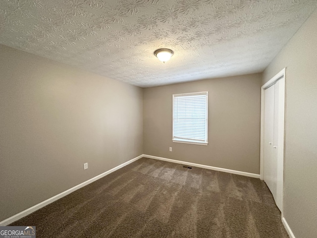 carpeted spare room with a textured ceiling