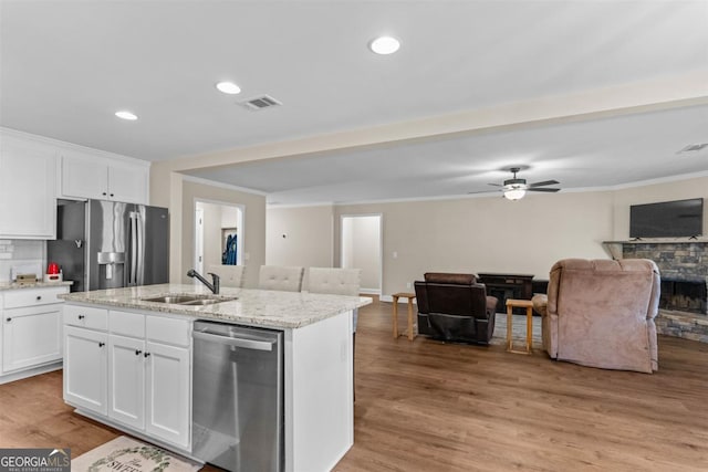 kitchen featuring a kitchen island with sink, sink, light hardwood / wood-style flooring, appliances with stainless steel finishes, and white cabinetry