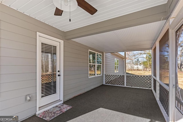 unfurnished sunroom featuring ceiling fan