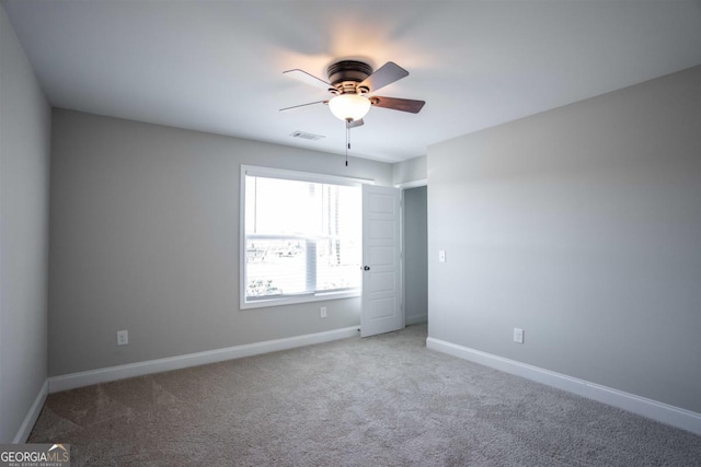 empty room featuring carpet flooring and ceiling fan