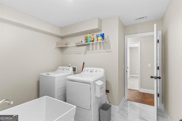 washroom with sink and independent washer and dryer