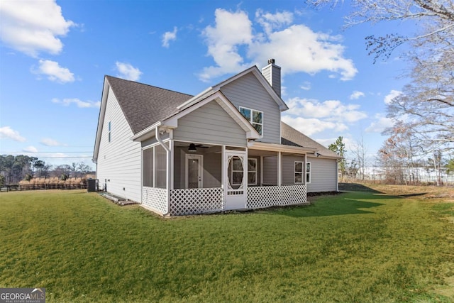 view of front of house with central air condition unit, a front lawn, and a sunroom