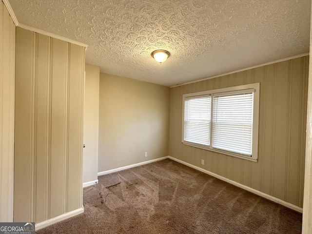 spare room featuring carpet flooring, crown molding, and a textured ceiling