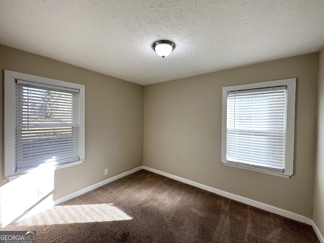 carpeted spare room with a textured ceiling