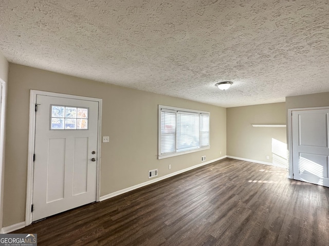 entryway with a textured ceiling and dark wood-type flooring