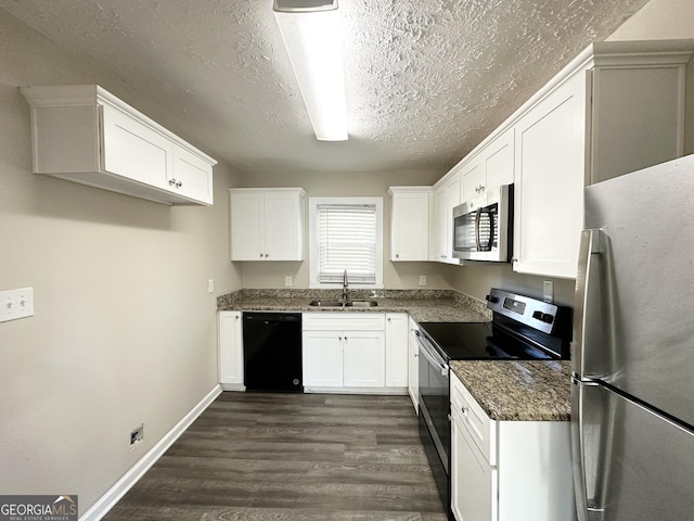 kitchen with sink, stainless steel appliances, dark hardwood / wood-style flooring, dark stone countertops, and white cabinets