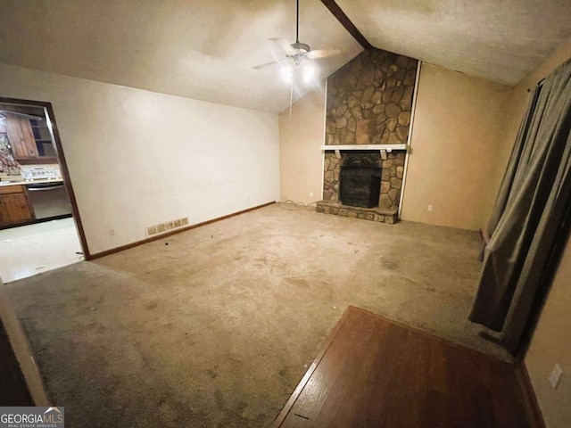 unfurnished living room with ceiling fan, a fireplace, carpet, and vaulted ceiling