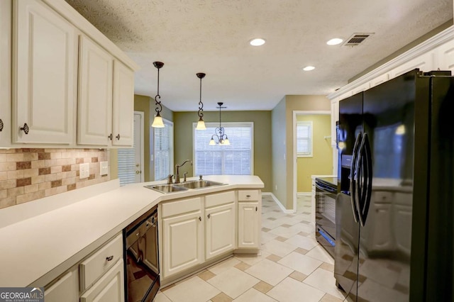 kitchen with kitchen peninsula, tasteful backsplash, sink, black appliances, and decorative light fixtures