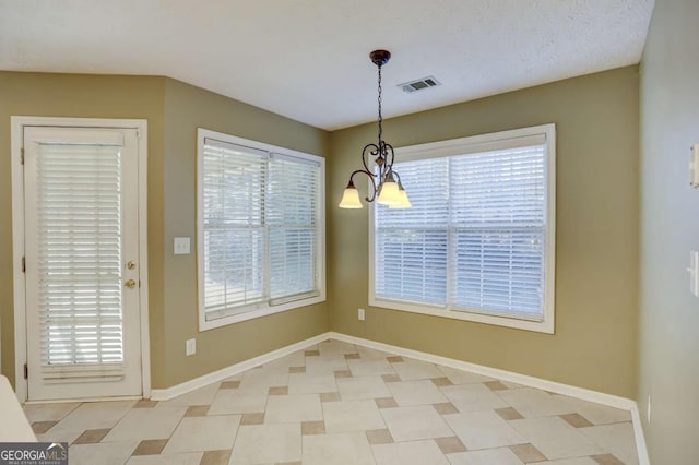 unfurnished dining area featuring a notable chandelier