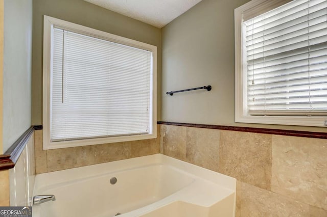 bathroom with a bathing tub and a textured ceiling