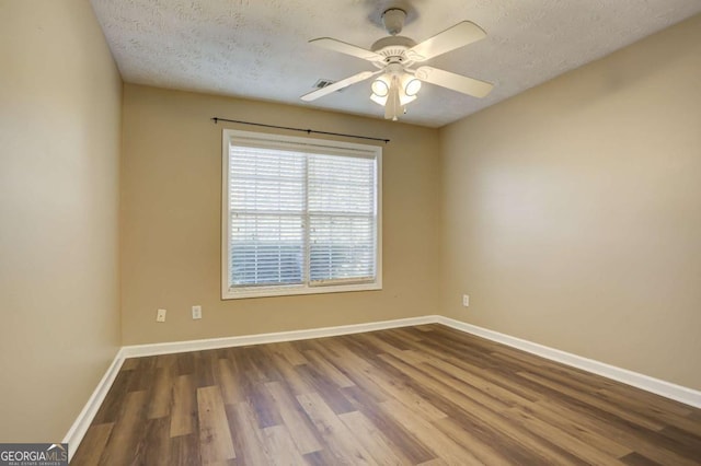 empty room with ceiling fan, a textured ceiling, and hardwood / wood-style flooring