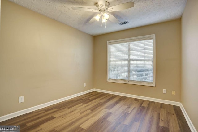 empty room featuring hardwood / wood-style flooring, ceiling fan, and a textured ceiling