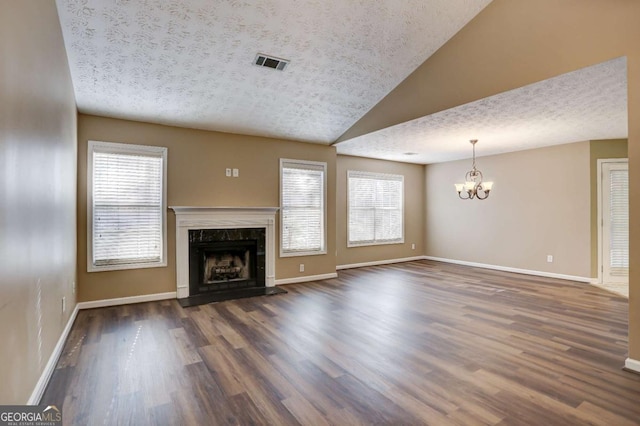 unfurnished living room with a high end fireplace, a chandelier, and a textured ceiling