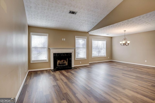 unfurnished living room featuring a fireplace, vaulted ceiling, a textured ceiling, and dark wood-type flooring