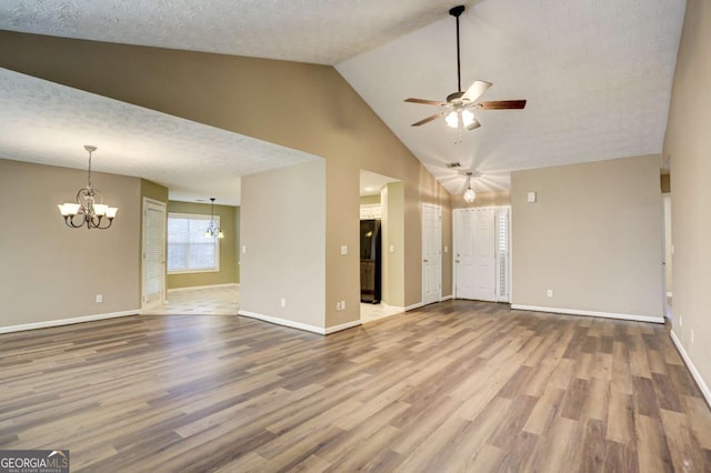 unfurnished living room featuring hardwood / wood-style floors, ceiling fan with notable chandelier, and a textured ceiling