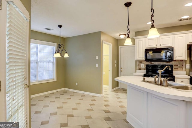 kitchen featuring white cabinets, sink, black appliances, a chandelier, and hanging light fixtures