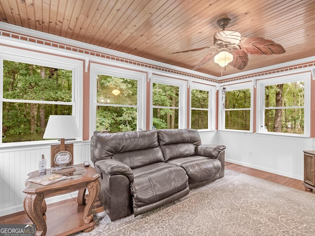 sunroom / solarium with ceiling fan, plenty of natural light, and wooden ceiling