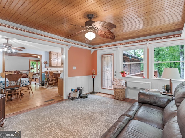 living room featuring wood ceiling, crown molding, ceiling fan, and light hardwood / wood-style floors