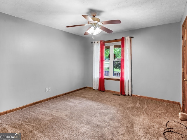 carpeted spare room with a textured ceiling and ceiling fan