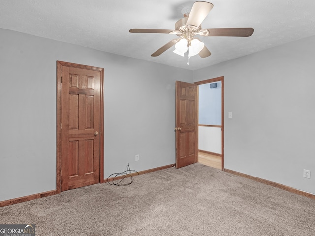 carpeted empty room featuring ceiling fan