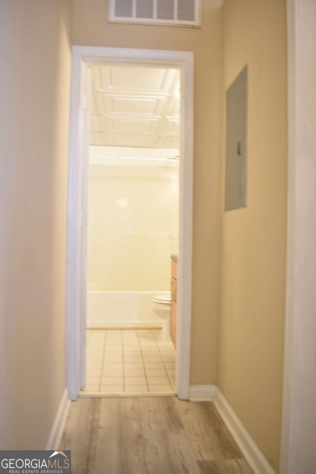 hall featuring electric panel and wood-type flooring