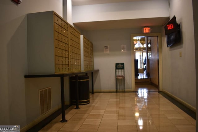 hall featuring mail boxes and light tile patterned floors