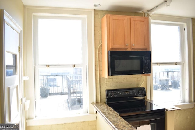 kitchen featuring black appliances and light stone counters