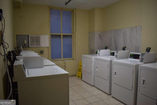 laundry area with washing machine and dryer and light tile patterned floors