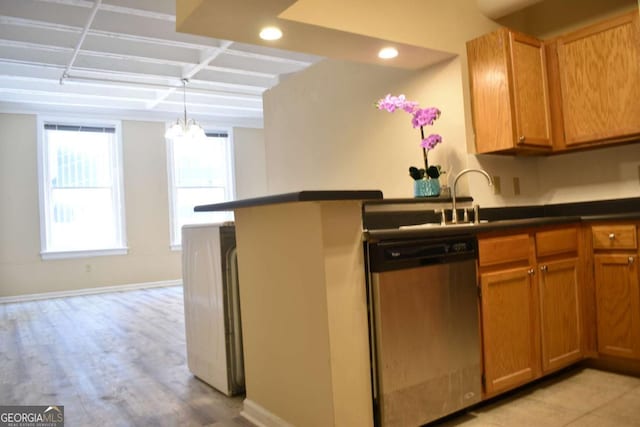 kitchen with sink, an inviting chandelier, stainless steel dishwasher, decorative light fixtures, and washer / dryer