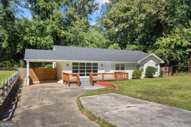 ranch-style house with a wooden deck, a front yard, and a carport