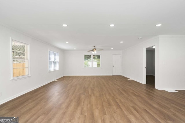 empty room with ceiling fan, crown molding, and wood-type flooring