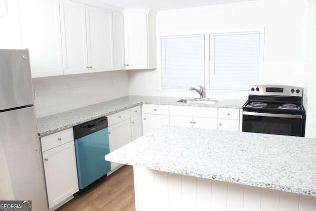 kitchen with appliances with stainless steel finishes, light stone counters, sink, hardwood / wood-style floors, and white cabinetry