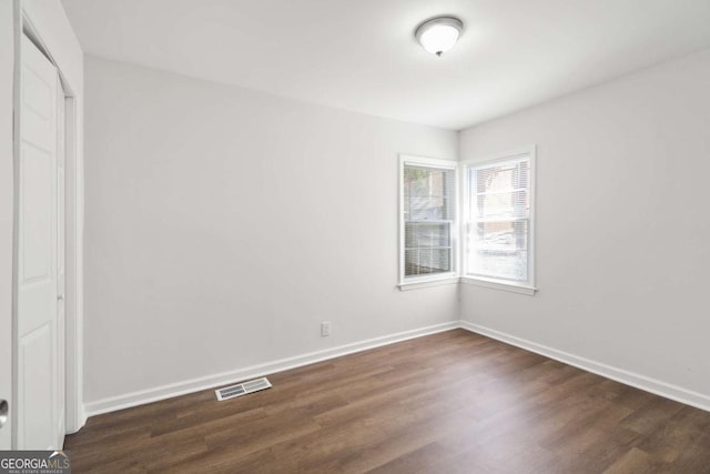 unfurnished room with dark hardwood / wood-style flooring