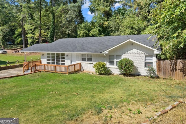 view of front of property with a deck and a front lawn