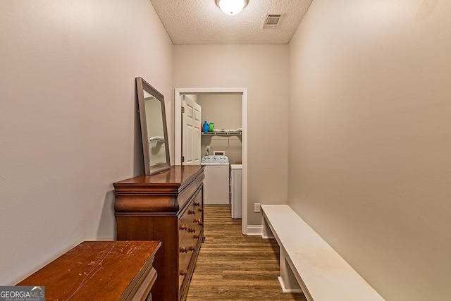 corridor with dark hardwood / wood-style floors, separate washer and dryer, and a textured ceiling