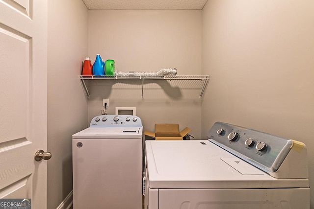 laundry area with a textured ceiling and washing machine and clothes dryer