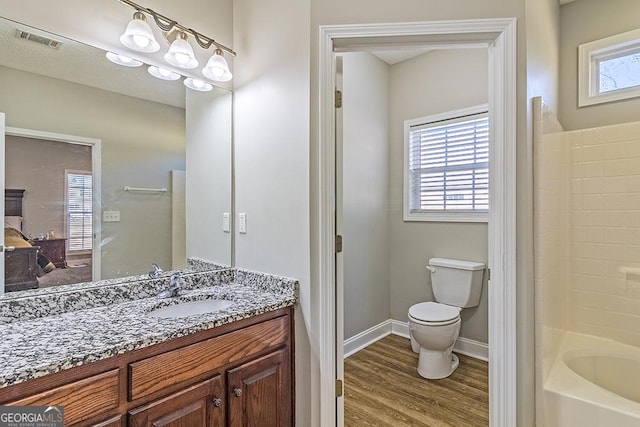 bathroom with hardwood / wood-style floors, vanity, and toilet