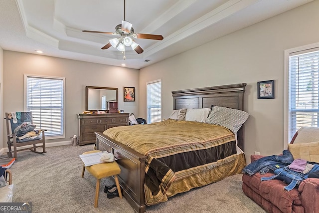 bedroom with ceiling fan, light colored carpet, ornamental molding, and a tray ceiling