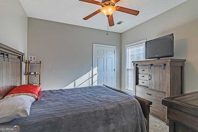 bedroom featuring ceiling fan and a textured ceiling