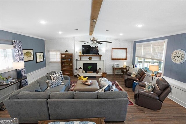 living room with beam ceiling, ceiling fan, brick wall, dark hardwood / wood-style floors, and a fireplace