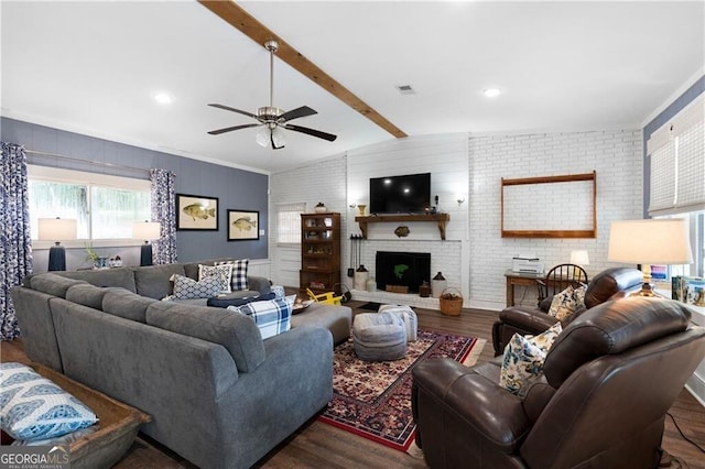 living room featuring lofted ceiling with beams, dark hardwood / wood-style floors, a brick fireplace, and brick wall