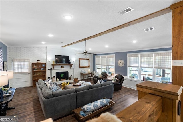 living room with dark hardwood / wood-style flooring, brick wall, ceiling fan, lofted ceiling with beams, and a fireplace