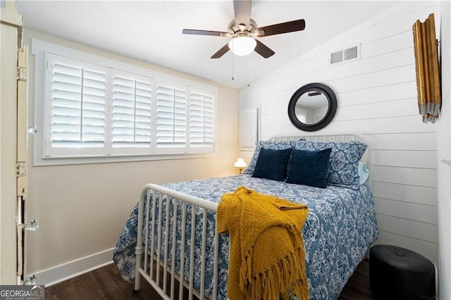 bedroom featuring ceiling fan, dark hardwood / wood-style flooring, and vaulted ceiling