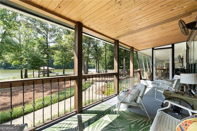 sunroom featuring a water view and wooden ceiling