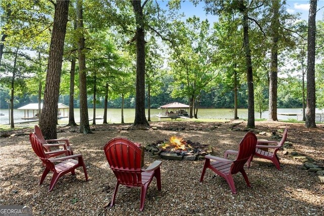 view of property's community featuring a fire pit, a gazebo, and a water view