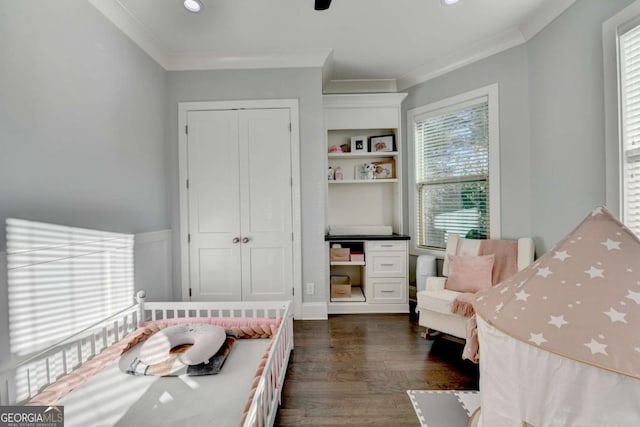 bedroom featuring multiple windows, dark hardwood / wood-style flooring, a closet, and crown molding